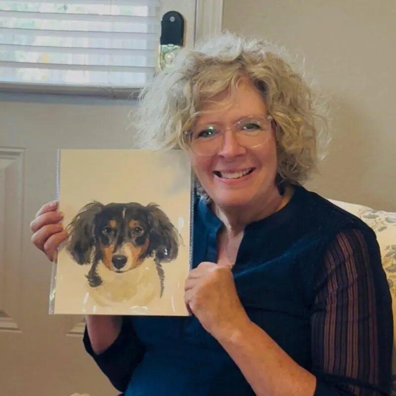 PaintMySoul customer holding a pet watercolor portrait