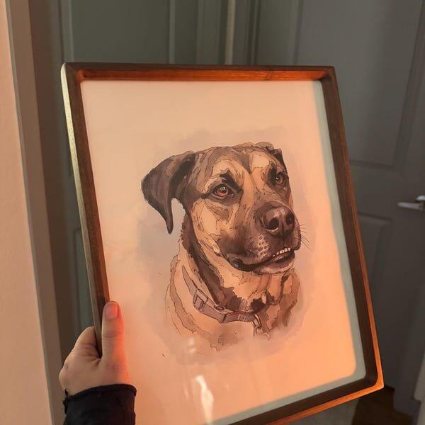 PaintMySoul customer holding a framed pet portrait