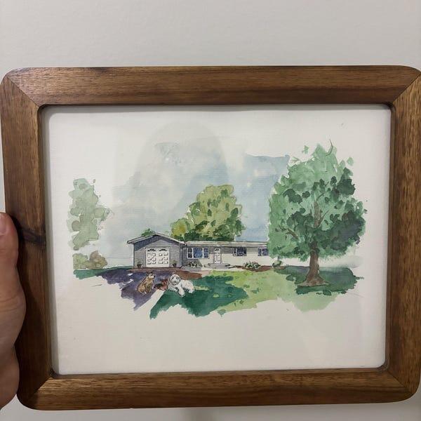 PaintMySoul customer holding a framed home portrait